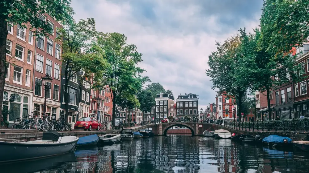 Seventeenth-century gabled canal houses reflected in an Amsterdam canal at dusk