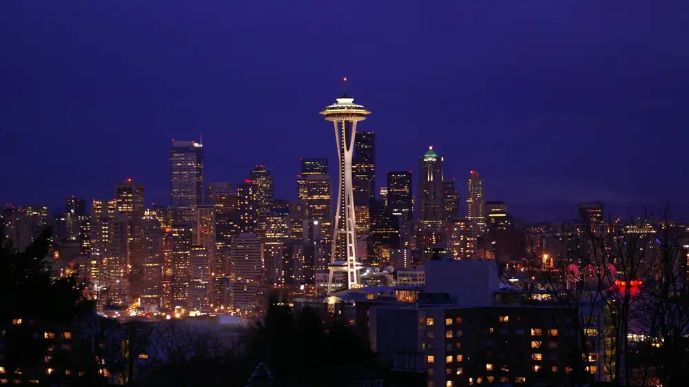 Elliott Bay and a ferry seen over the roofs of Pike Place Market at dusk