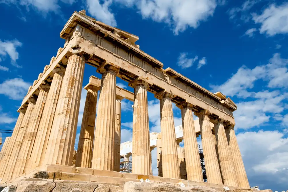 The Parthenon seen from an Athens rooftop terrace at dusk with the city below