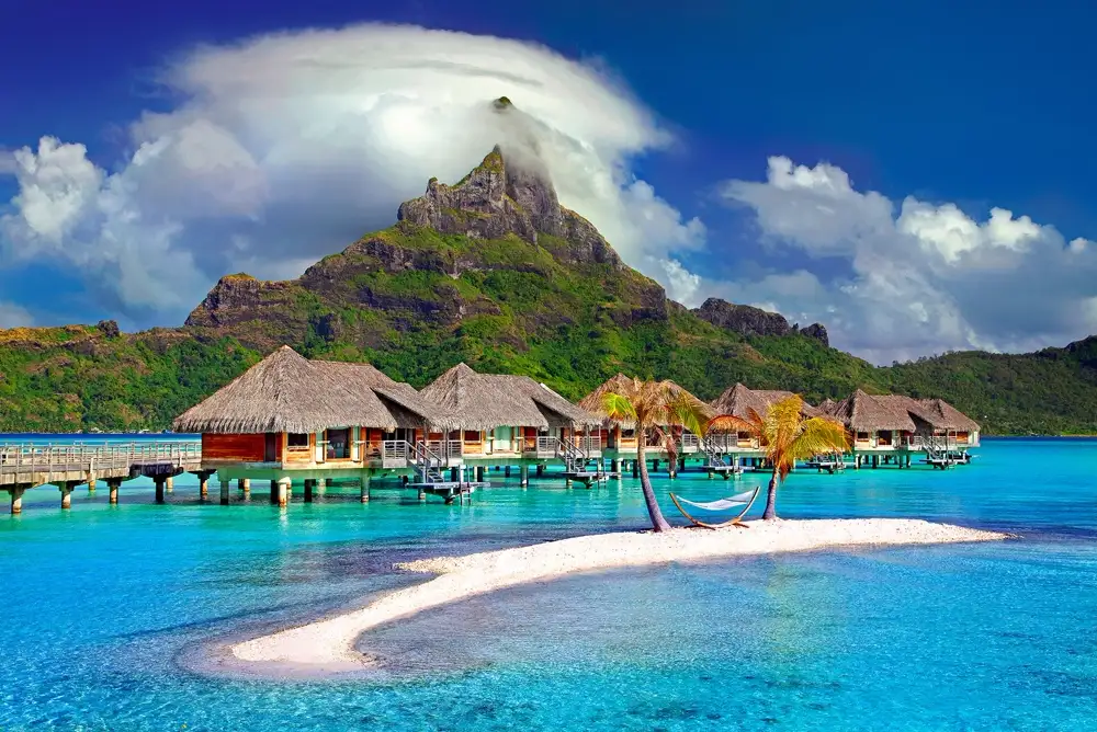 Overwater bungalows on the Bora Bora lagoon with Mount Otemanu behind them