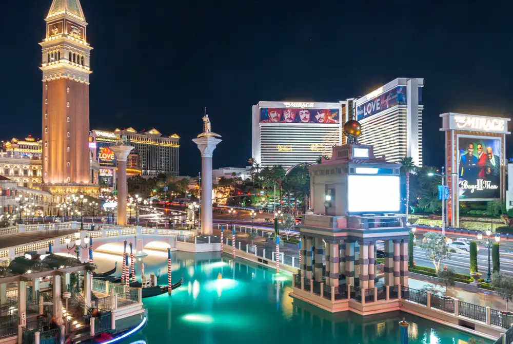The Bellagio fountains lit at night with the centre Strip resorts behind