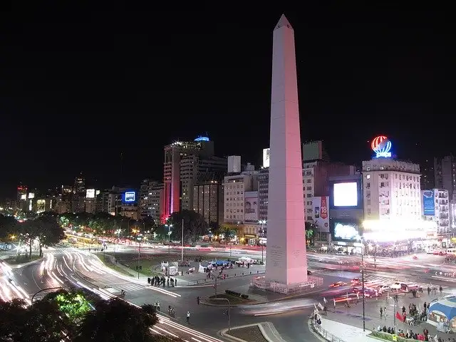 A leafy Palermo street in Buenos Aires with restaurant tables out at night