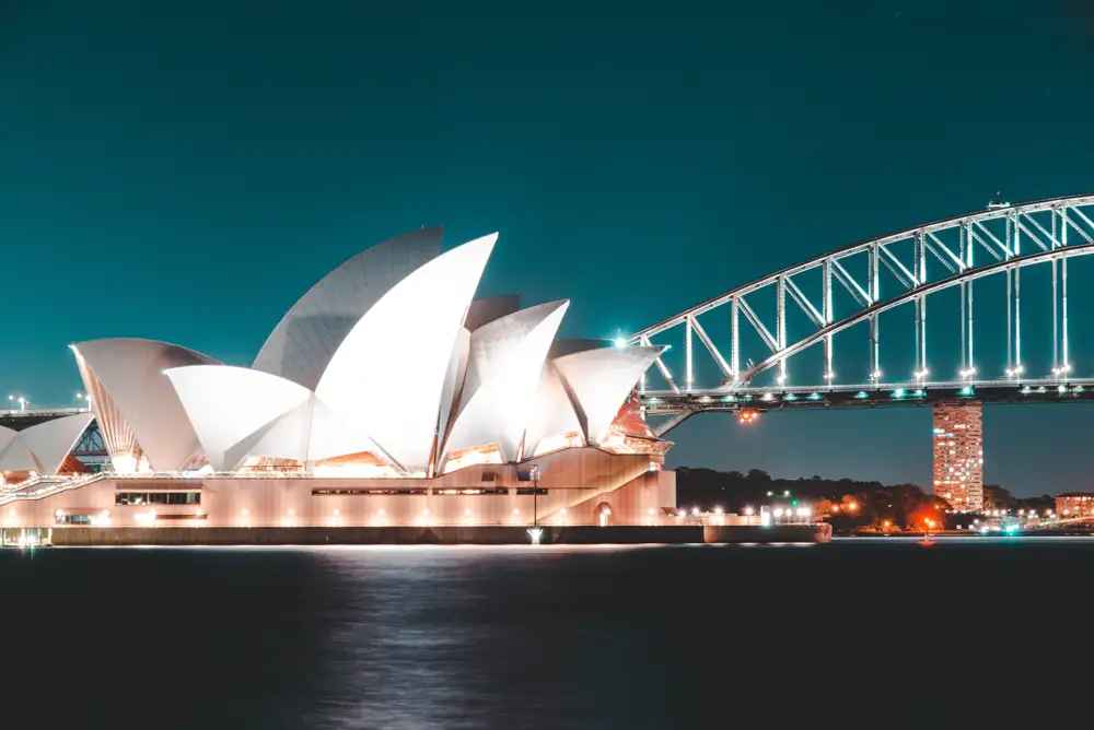 Sydney Harbour at dusk with the Opera House and Harbour Bridge and a ferry crossing