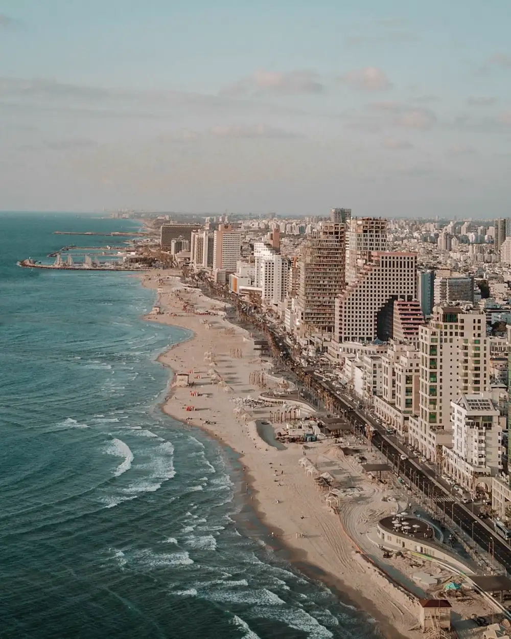 The Tel Aviv beach promenade curving south toward Jaffa at sunset